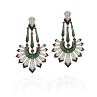 A pair of Art Deco style drop earrings featuring green emerald-cut stones, black enamel, and pavé-set clear stones on a white background.