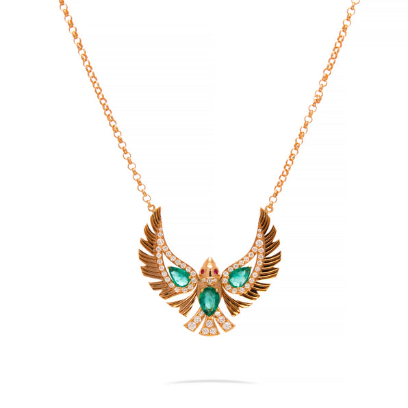 A rose gold necklace with a winged pendant featuring green emerald-cut stones and small clear accent stones, shown on a white background.